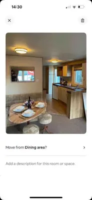 a living room with a table and chairs and a kitchen at AJ’s Caravan Hire in Aberystwyth