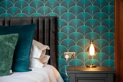 a bedroom with a bed with a green wall at The Belmont Barmouth in Barmouth
