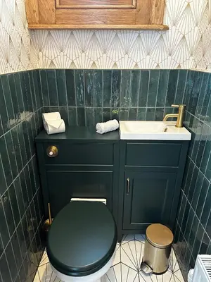a bathroom with a black toilet and a sink at The Belmont Barmouth in Barmouth