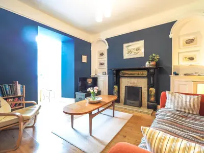 a living room with a table and a fireplace at Brodawel New Quay in New Quay