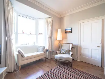 a living room with a couch and a chair and a window at Brodawel New Quay in New Quay