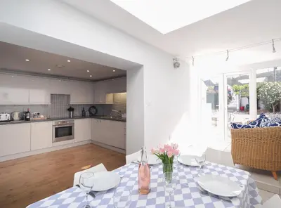 a kitchen and dining room with a table with flowers on it at Brodawel New Quay in New Quay