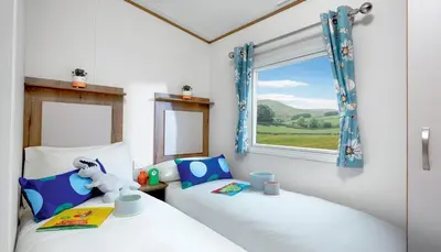 two twin beds in a room with a window at WH - Smugglers Cove 01 in Aberaeron