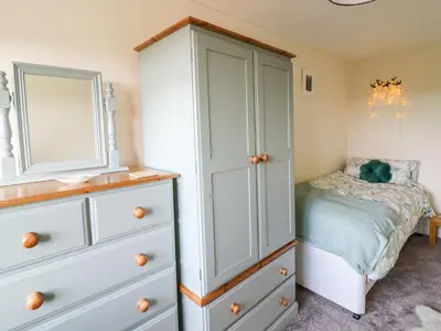 a bedroom with a dresser and a bed at Blaenferwig in New Quay