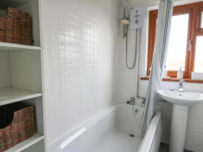 a white bathroom with a sink and a tub and a toilet at Blaenferwig in New Quay