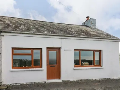 a white house with brown doors and windows at Blaenferwig in New Quay