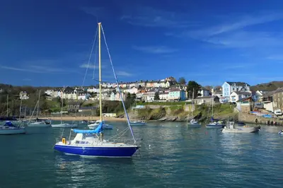 a sail boat in the water in a harbor at No. 1 Cliffside New Quay in New Quay