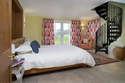 a bedroom with a white bed and a staircase at Ty Cellin Tregaron in Ystrad-Meurig