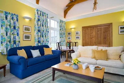 a living room with two blue couches and a table at Ty Cellin Tregaron in Ystrad-Meurig
