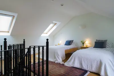two beds in a white room with skylights at Ty Cellin Tregaron in Ystrad-Meurig