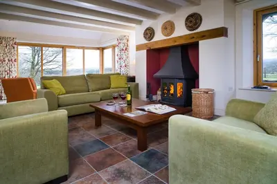 a living room with two couches and a fireplace at Bryn Isaf Tregaron in Ystrad-Meurig