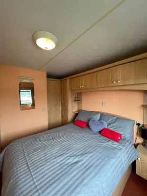 a bedroom with a bed with two stuffed animals on it at Spacious 2 bedroomed mobile home in Aberystwyth