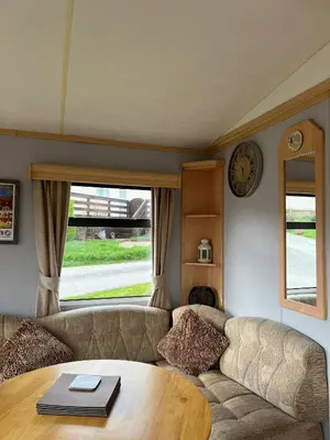 a living room with a couch and a table at Spacious 2 bedroomed mobile home in Aberystwyth