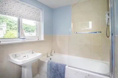 a bathroom with a tub and a sink and a shower at Ellesmere New Quay in New Quay