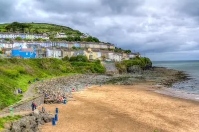 a group of people on a beach near the ocean at Ellesmere New Quay in New Quay