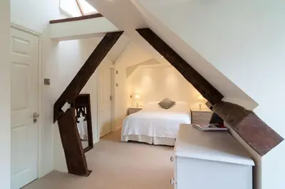 a attic bedroom with a bed and a window at Grade 2 listed , In the heart of Historic Ludlow. in Ludlow