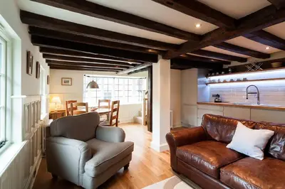 a living room with a leather couch and a table at Grade 2 listed , In the heart of Historic Ludlow. in Ludlow