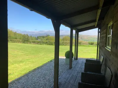 a porch of a house with a view of a field at Cabin in the hills near Dolgellau in Dolgellau