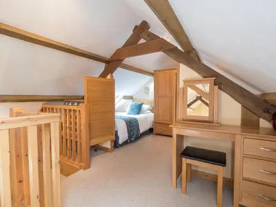 a bedroom with a bed and a desk with a desk at Eirlys Aberystwyth in Llanrhystyd