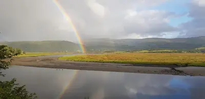a rainbow in the middle of a river at Cae Mawr Borth and Ynyslas in Scyborycoed