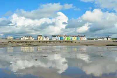a reflection of clouds in the water on a beach at Cae Mawr Borth and Ynyslas in Scyborycoed