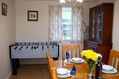 a kitchen with a stove and a table with chairs at Soar Cottage Aberystwyth in Aberystwyth