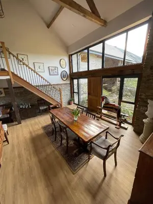 a living room with a wooden table and a staircase at The Granary Wales in Kington