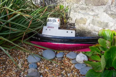 a small boat sitting on the ground next to some plants at Townhouse Aberystwyth in Aberystwyth