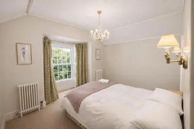a bedroom with a white bed and a window at Glandwr hall - 6 Bed - Magnificent Country House with Heated Swimming Pool & Jacuzzi in Barmouth