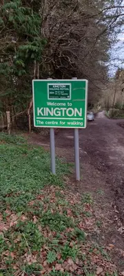 a green sign in the middle of a road at Kington Accommodation in Kington