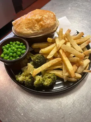 a plate of food with broccoli and a sandwich and peas at Aleppo Merchant Inn in Carno