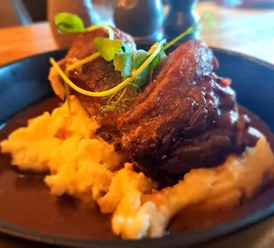 a plate of food with meat and mashed potatoes at Aleppo Merchant Inn in Carno