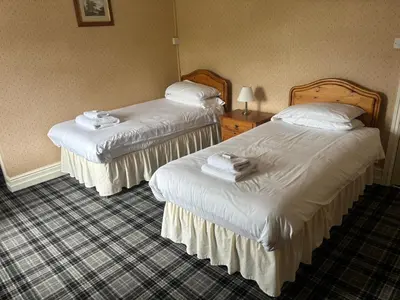 a hotel room with two beds with towels on them at Aleppo Merchant Inn in Carno