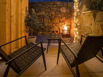 a patio with two chairs and a table with lights at Llety Cariad in Bala