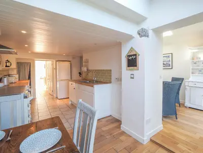 a kitchen and dining room with a table and chairs at Glenydd New Quay in New Quay