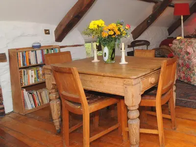 a wooden table with a vase of flowers on it at The Old Mill Devils Bridge in Llanilar