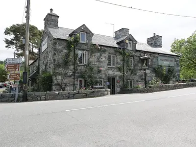 an old stone building on the side of a road at Anadlu in Llanbedr
