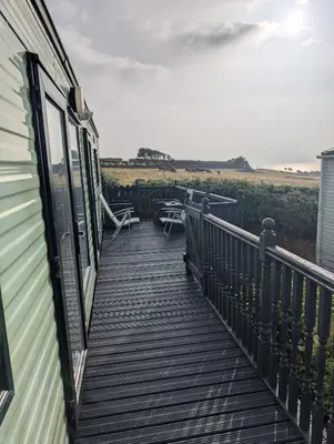 a deck with tables and chairs on a house at 64 Wide Horizon in Aberaeron