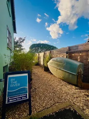 a boat sitting on the ground next to a sign at By the River in Glasbury