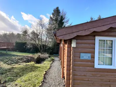 a log cabin with a sign on the side of it at Serene Snowdonia Retreat in Trawsfynydd