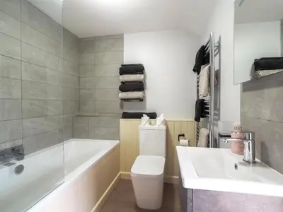 a bathroom with a tub and a toilet and a sink at Bryndalis Aberaeron in Ciliau-Aeron