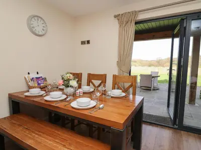 a dining room table with a clock on the wall at Caban Dulas in Rhayader