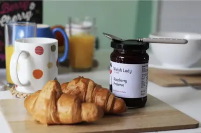 a cutting board with croissants and a jar of jam at The Heron's Tree in Llandovery