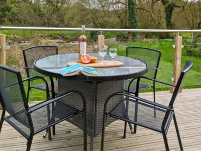 a table with a bottle of wine and two glasses at The Heron's Tree in Llandovery