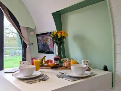 a table with two cups and a vase of flowers at The Heron's Tree in Llandovery