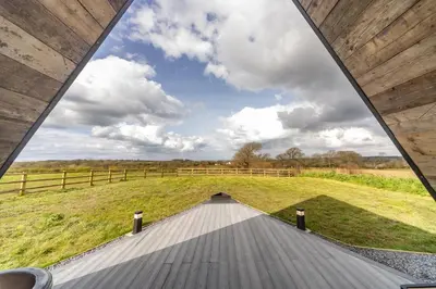 a wooden walkway leading to a field with a fence at The Tri-Pod in Llanarth