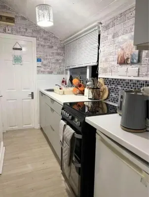 a kitchen with a stove and a counter top at No. 4 Sunny Lodge By The Sea in Aberystwyth