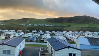 a group of houses with a mountain in the background at No. 4 Sunny Lodge By The Sea in Aberystwyth