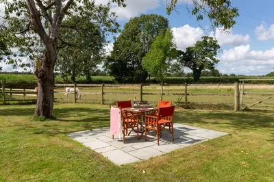 a table and chairs sitting next to a tree at Stunning studio flat with dedicated private garden in Shrewsbury