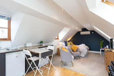 a kitchen and living room with a bed and a table at Stunning studio flat with dedicated private garden in Shrewsbury